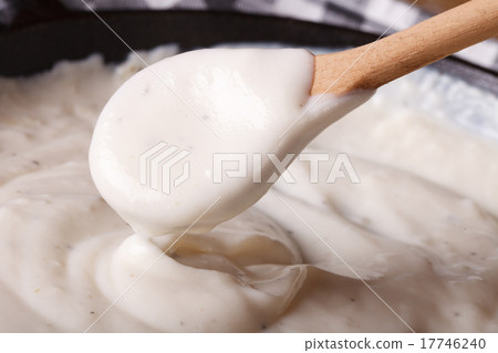 bechamel sauce with a wooden spoon close-up 17746240