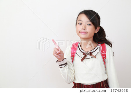 A cute elementary school girl pointing to a point A cute elementary school girl pointing to a point 17748958