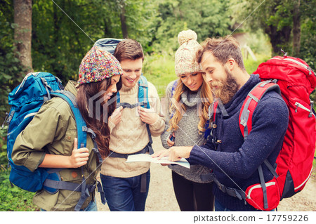 Stock Photo: group of smiling friends with backpacks hiking