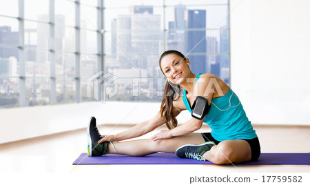 smiling woman stretching leg on mat over gym smiling woman stretching leg on mat over gym 17759582