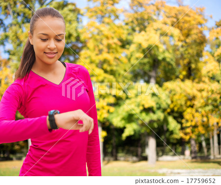 smiling woman with heart rate watch at autumn park smiling woman with heart rate watch at autumn park 17759652