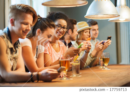 happy friends with smartphones and drinks at bar 17759713
