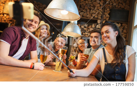 friends with smartphone on selfie stick at bar 17759850