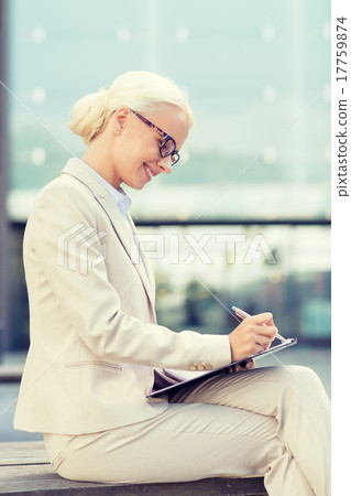young smiling businesswoman with notepad outdoors 17759874