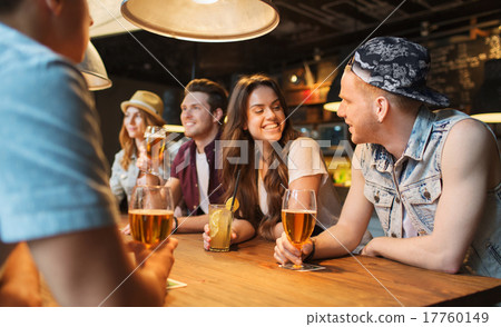 happy friends with drinks talking at bar or pub 17760149