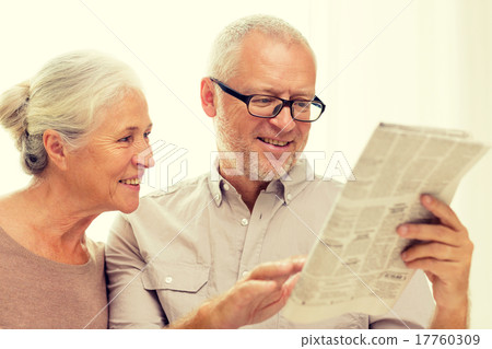 happy senior couple reading newspaper at home happy senior couple reading newspaper at home 17760309