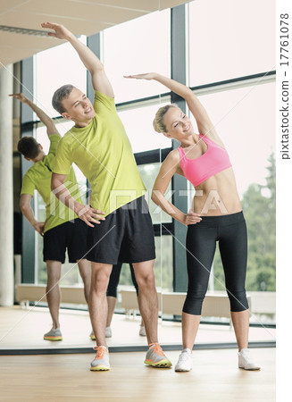 smiling man and woman exercising in gym 17761078