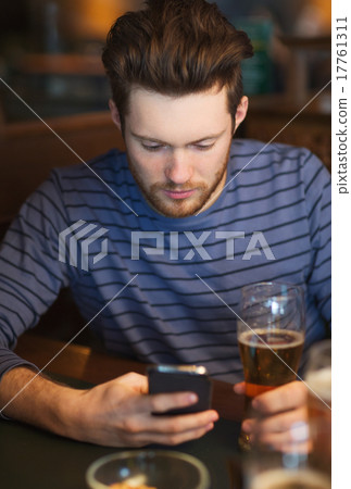 man with smartphone drinking beer at bar man with smartphone drinking beer at bar 17761311