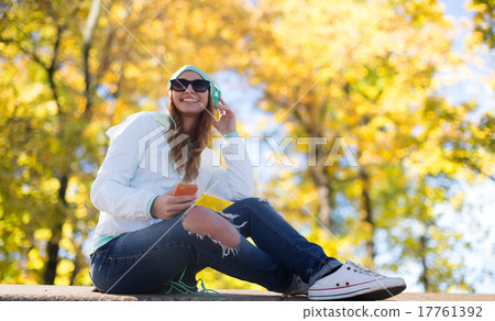 happy young woman with smartphone and headphones 17761392
