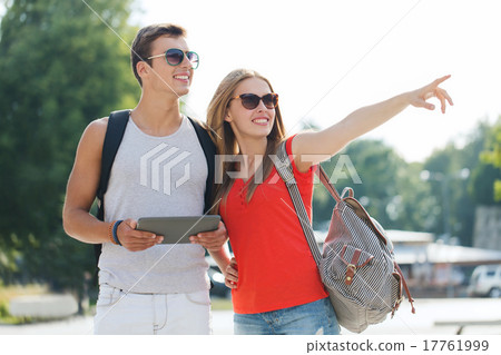 smiling couple with tablet pc and backpack in city smiling couple with tablet pc and backpack in city 17761999
