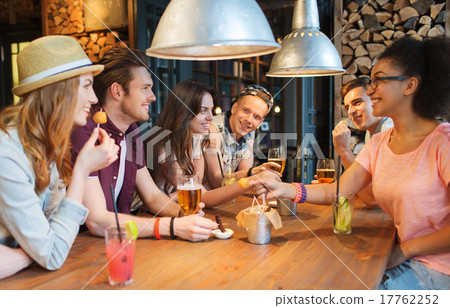 happy friends with drinks talking at bar or pub 17762252