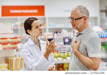 pharmacist showing drug to senior man at pharmacy 17762294