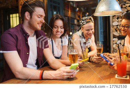 happy friends with smartphones and drinks at bar 17762530