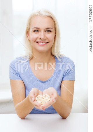 happy woman holding pills or capsules at home 17762693