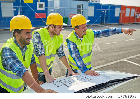 close up of builders with blueprint on car hood close up of builders with blueprint on car hood 17762955