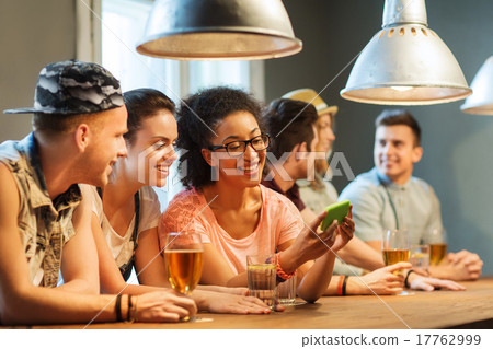 happy friends with smartphone and drinks at bar 17762999