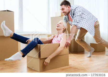 Stock Photo: couple with cardboard boxes having fun at new home