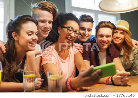 happy friends with smartphone taking selfie at bar 17763146