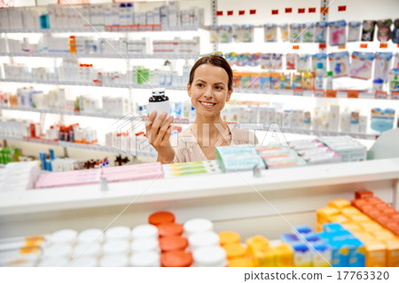 happy female customer with drug jar at pharmacy happy female customer with drug jar at pharmacy 17763320