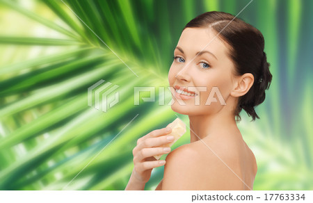 woman with soap over green palm leaf background 17763334