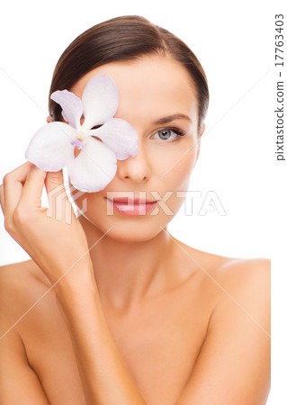 relaxed woman with orchid flower over eye 17763403