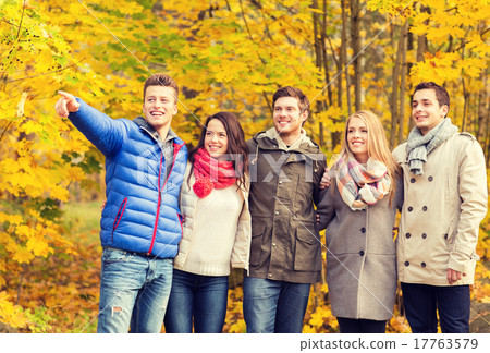 group of smiling men and women in autumn park group of smiling men and women in autumn park 17763579