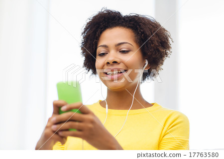 happy african woman with smartphone and earphones happy african woman with smartphone and earphones 17763580