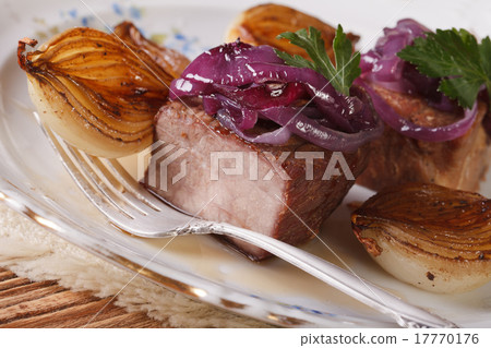 Meat with caramelized onions on a plate closeup.  17770176