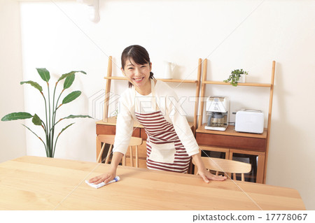 A woman wiping a table 17778067