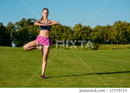Girl is engaged the pilates on a golf course. Girl is engaged the pilates on a golf course. 17779725