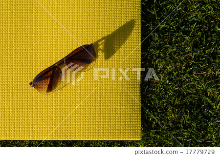Sunglasses lying on a yoga mat Sunglasses lying on a yoga mat 17779729