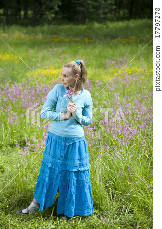 beautiful young woman in a blue dress in the field 17797278