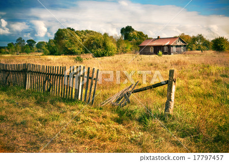Old house with wooden fence on the empty meadow 17797457
