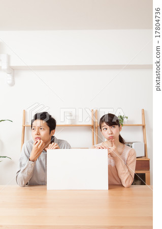 A male and female couple with a troubled face with a whiteboard 17804736