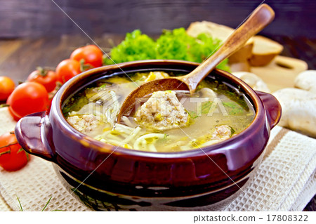 Soup with meatballs and spoon in pottery on board 17808322