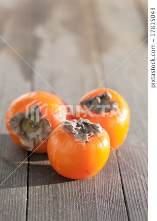 Three tasty persimmons on wooden table 17815043