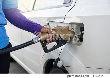 Hand hold Fuel nozzle to add fuel in car at filling station 17823402