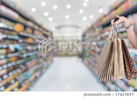Holding shoping bags by hand on Supermarket blur background with Holding shoping bags by hand on Supermarket blur background with 17823647