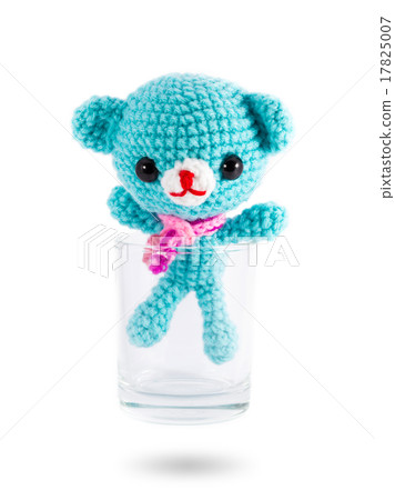 handmade crochet blue bear doll in vodka glass on white backgrou 17825007
