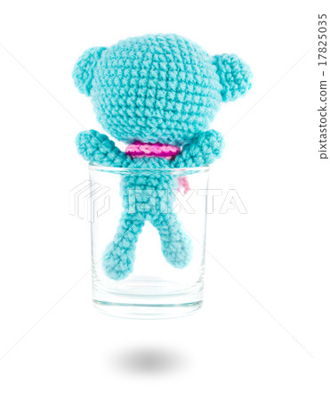 handmade crochet blue bear doll in vodka glass on white backgrou 17825035