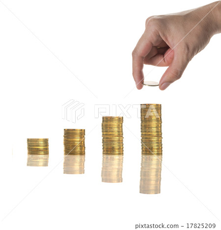 Hand holding and adding a golden coin on the stacks of golden co 17825209