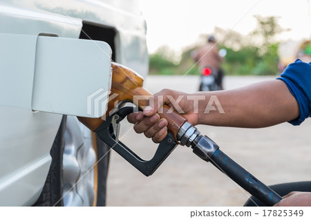 Hand hold Fuel nozzle to add fuel in car at filling station Hand hold Fuel nozzle to add fuel in car at filling station 17825349