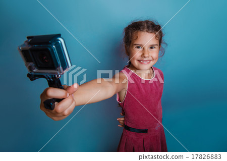 Girl child holding a camera in his hand shooter 17826883