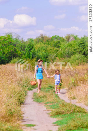 Girls sister in a field with a basket and flowers Girls sister in a field with a basket and flowers 17833830