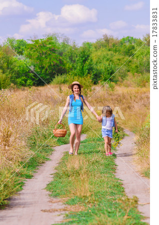 Girls sister in a field with a basket and flowers Girls sister in a field with a basket and flowers 17833831