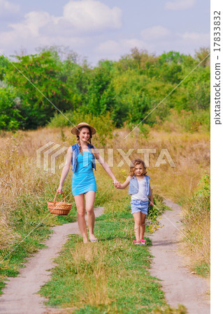 Girls sister in a field with a basket and flowers Girls sister in a field with a basket and flowers 17833832