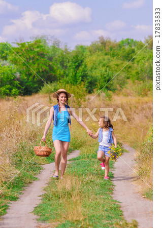 Girls sister in a field with a basket and flowers 17833833