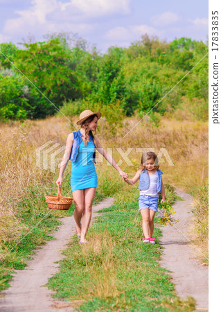Girls sister in a field with a basket and flowers Girls sister in a field with a basket and flowers 17833835
