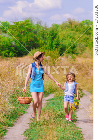 Girls sister in a field with a basket and flowers Girls sister in a field with a basket and flowers 17833836