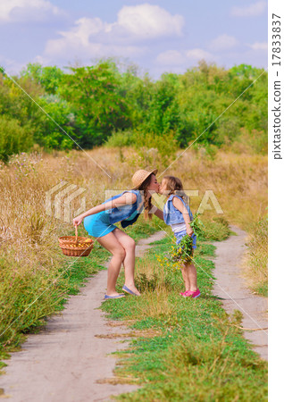 Girls sister in a field with a basket and flowers 17833837